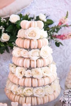 a wedding cake made out of macaroni shells and white roses on a table