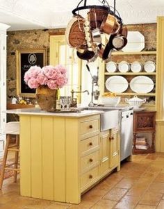 a kitchen filled with lots of yellow cabinets and counter top covered in pots and pans