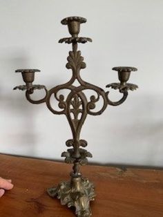 a small metal candelabra sitting on top of a wooden table