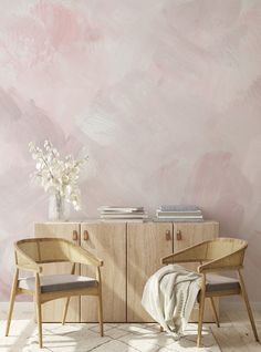 two chairs sitting next to each other in front of a wall with pink paint on it