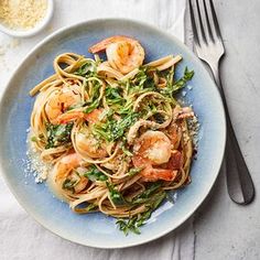 a plate of pasta with shrimp, spinach and parmesan cheese