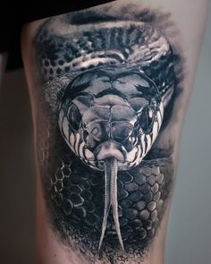 a black and white photo of a snake on the thigh