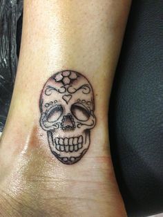 a small skull tattoo on the ankle