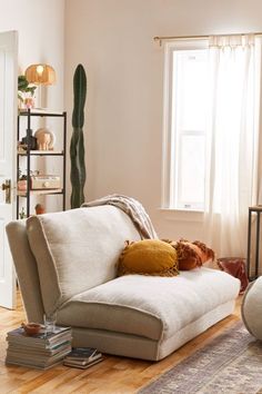 a living room filled with furniture and a large cactus in the corner on the wall