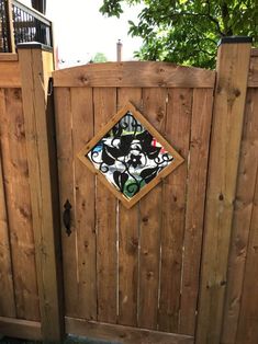 a wooden fence with a painting on the top and bottom part of it's gate