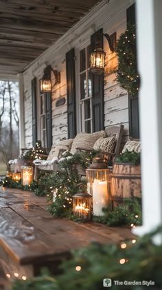 the porch is decorated for christmas with candles and greenery