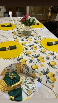 the table is set with yellow and green place mats, napkins, and flowers