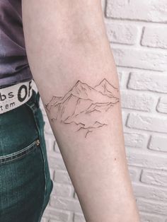 a person with a mountain tattoo on their arm