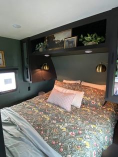 a bed in a room with green walls and pictures on the headboard above it