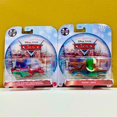 two disney pixars cars are on display in their packaging boxes, one is green and the other is red