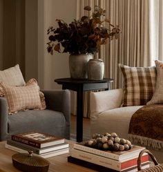 a living room filled with lots of furniture and books on top of a coffee table