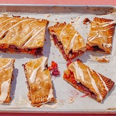 several pastries sitting on top of a baking pan covered in icing and toppings