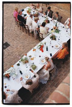 a group of people sitting around a long table