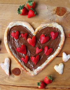 a heart shaped pastry with chocolate frosting and strawberries