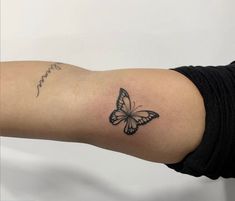 a woman's arm with a small butterfly tattoo on the left side of her arm