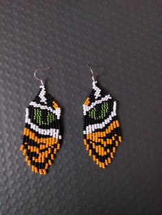 the beaded earrings are designed to look like an insect