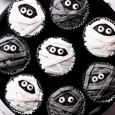 cupcakes decorated with white frosting and black icing in the shape of eyes