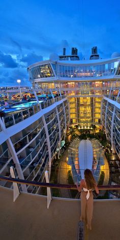 a woman standing in front of a cruise ship looking at the pool and surrounding buildings