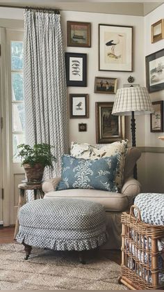 a living room with pictures on the wall and a chair next to a footstool