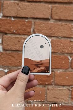 a person holding up a sticker with the word'stop'on it in front of a brick wall