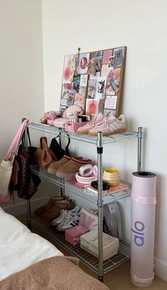 there is a shelf with shoes and other items on it in the corner next to a bed