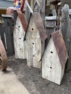 several wooden birdhouses sitting next to each other