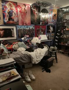 a messy bedroom with posters on the wall