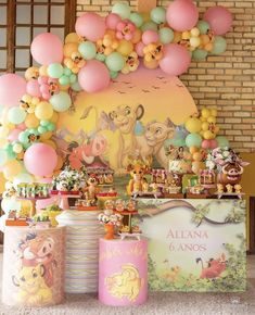 a table with winnie the pooh decorations and balloons