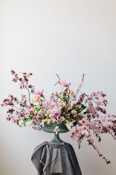 a vase filled with lots of flowers on top of a table