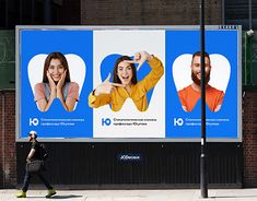 a large advertisement on the side of a building in front of a woman walking by