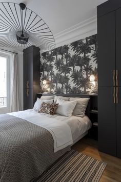 a bedroom with black and white palm trees on the wall