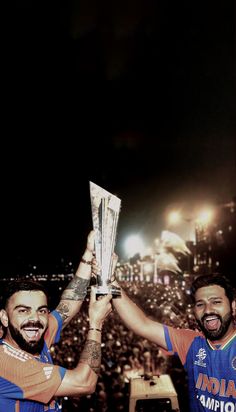 two men are holding up their trophies in front of a crowd