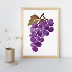 a painting of purple grapes in a wooden frame next to a vase