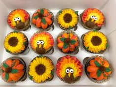 cupcakes decorated with sunflowers and fake turkey faces are in a box