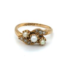 This superb 18k gold ring is set with a trio of pearls flanked by six old cut diamonds. It dates from the early 20th century (1911). The ring has an unusual crossover design and is a very chic, easy to wear piece for your collection. Details Ring size: UK Q Weight: 3.7g Age: Edwardian Materials 18k gold (hallmarks 18k, Birmingham and 1911), pearl and diamond   Condition Notes Good used condition in line with age-related wear. Vintage Gold Pearl Ring With Rose Cut Diamonds, Pearl Rings Vintage, Edwardian Ring, Antique Jewelry Rings, Edwardian Jewelry, Pearl And Diamond Ring, 18k Gold Ring, Bling Rings, Pretty Rings