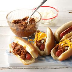 three hot dogs with chili, cheese and sour cream