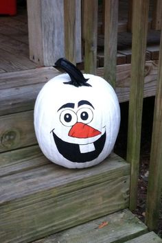 a white pumpkin with a face painted on it