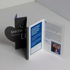 an open brochure with a black cat on the front and blue back side