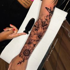 a woman's arm with flowers and a butterfly on it