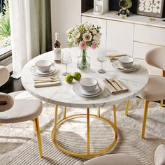 a dining room table with plates and bowls on it