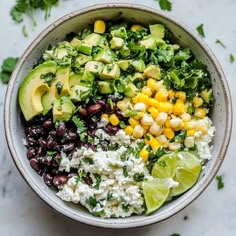 a bowl filled with black beans, corn, avocado and cilantro