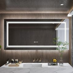 a bathroom with marble counter tops and a large mirror over the sink that's illuminated