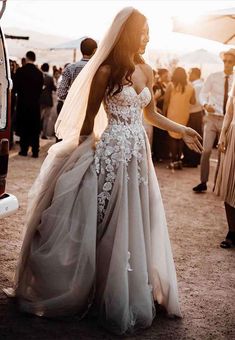 a woman in a wedding dress standing next to a van