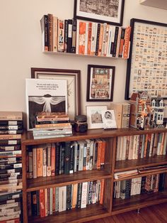 a bookshelf filled with lots of books on top of a hard wood floor