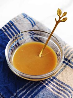 a glass bowl filled with sauce on top of a blue and white towel