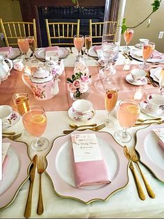 the table is set with pink and gold china