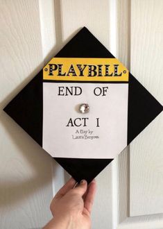 someone is holding up a black and yellow graduation cap that says, playbill end of act