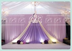 a purple and white wedding setup with chandelier