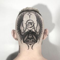 a man's head with a skull and wings tattoo on the side of his head