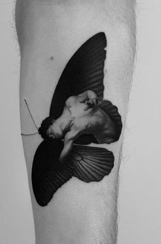 a black and white photo of a man's leg with a bird on it